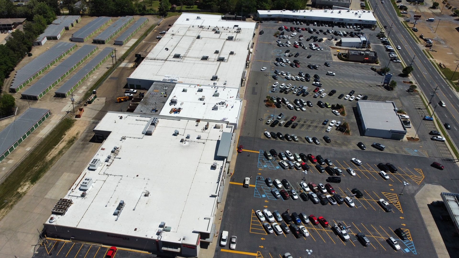 An aerial view of a large building with a lot of cars parked in front of it.