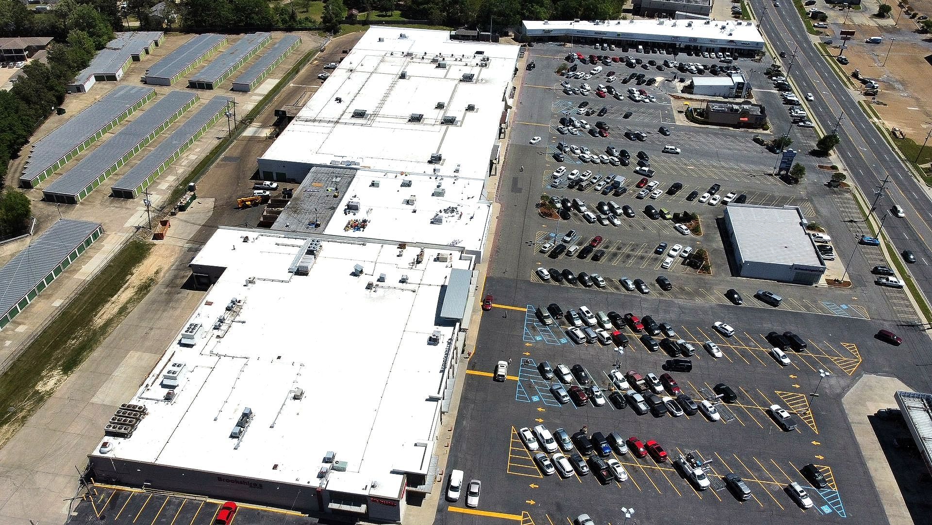 An aerial view of a large building with a lot of cars parked in front of it