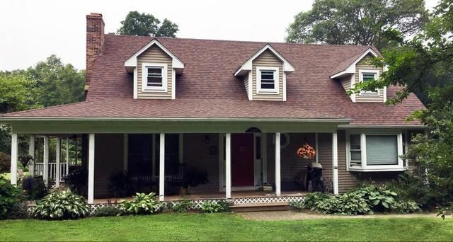 A large house with a porch and a red door