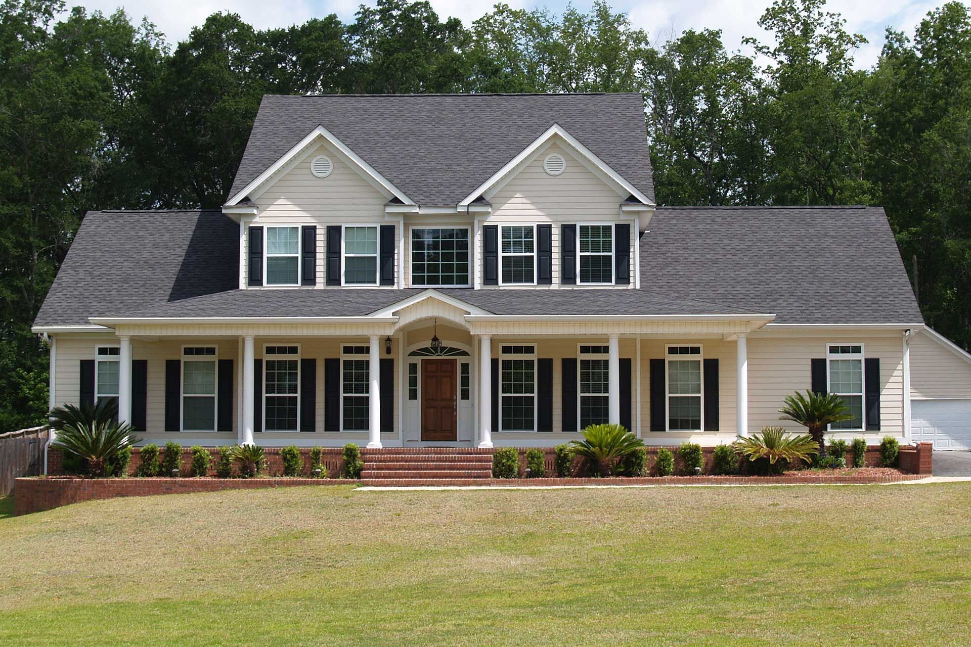 A large white house with black shutters on the windows