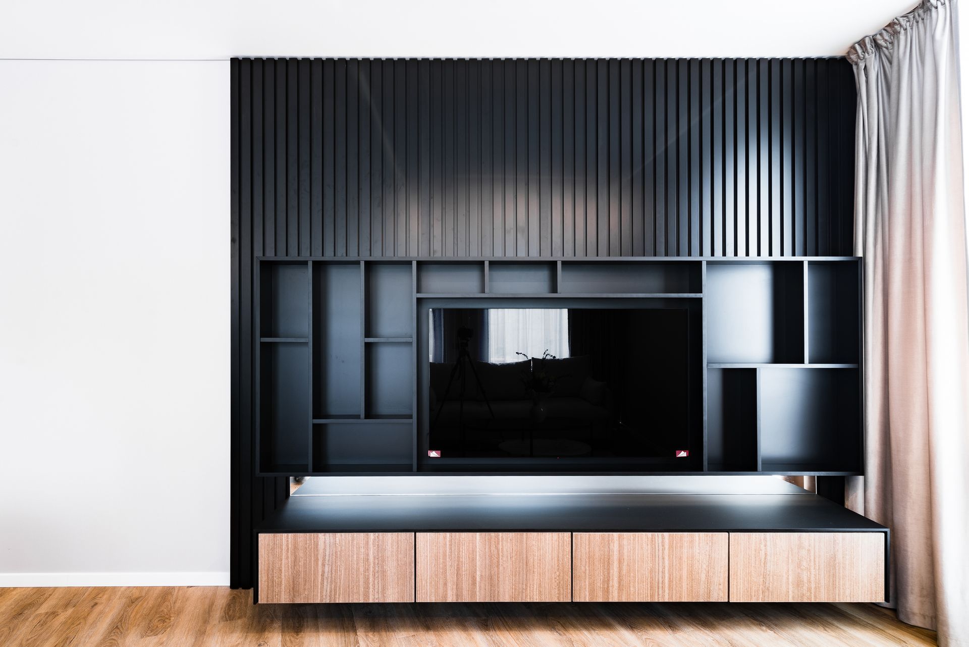 Large black TV shelf in a living room of an apartment, perfect for big screens. Large black TV shelf in a living room of an apartment, perfect for big screens.