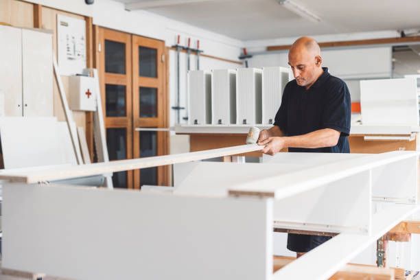 Carpenter assembling custom cabinets with a plastic hammer for a smooth finish.