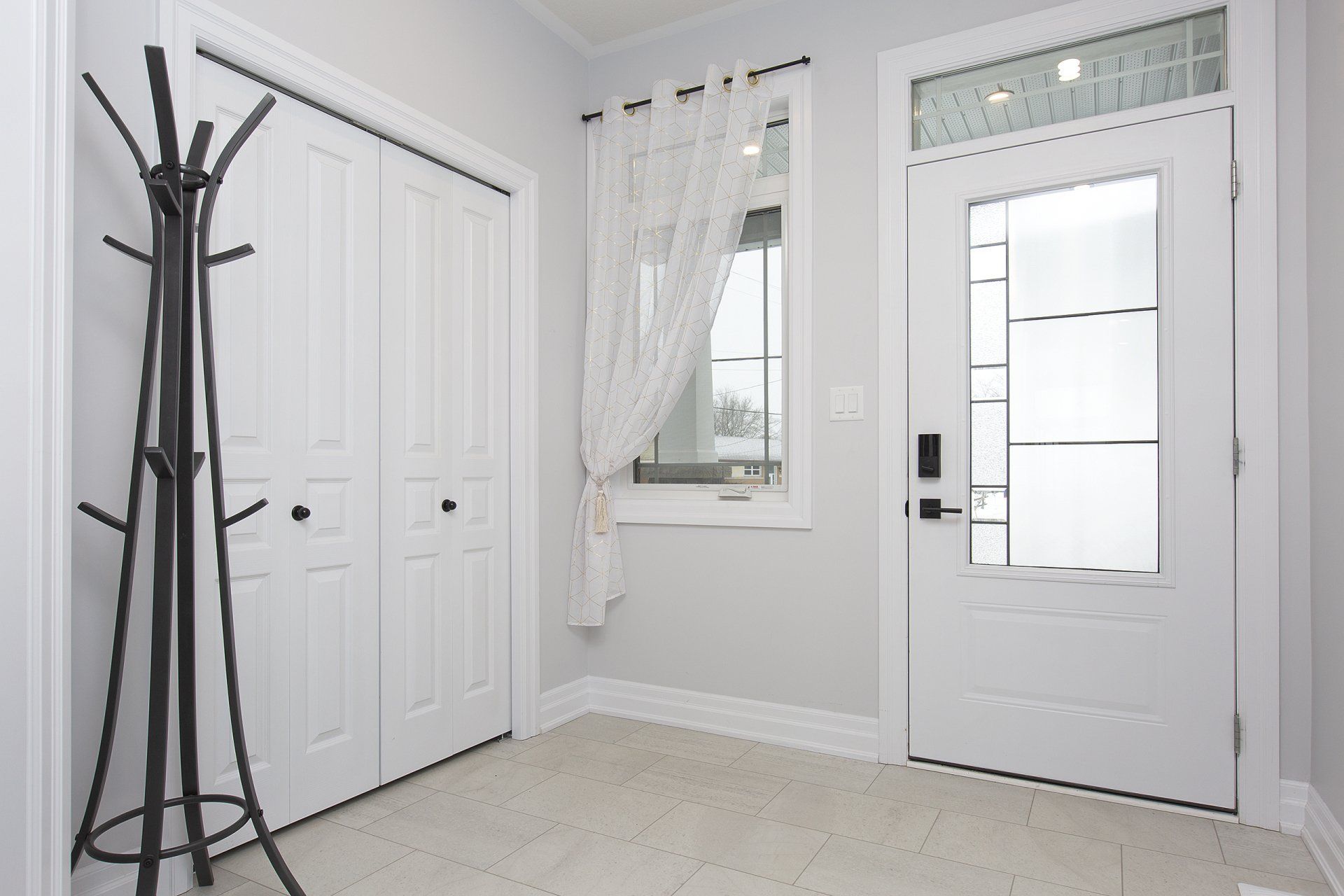 There is a coat rack in the hallway next to the door.