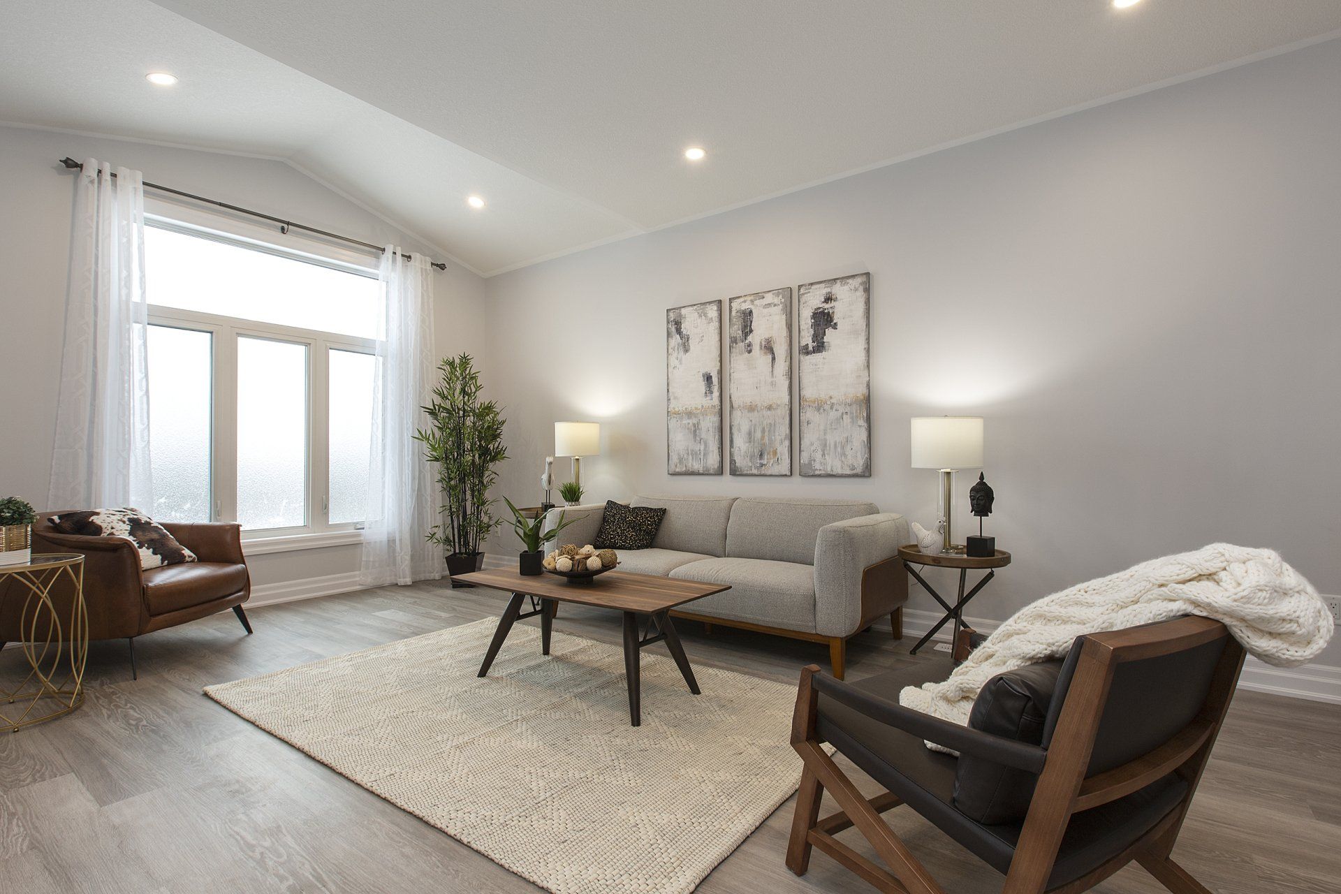 A living room with a couch , chair , coffee table and rug.