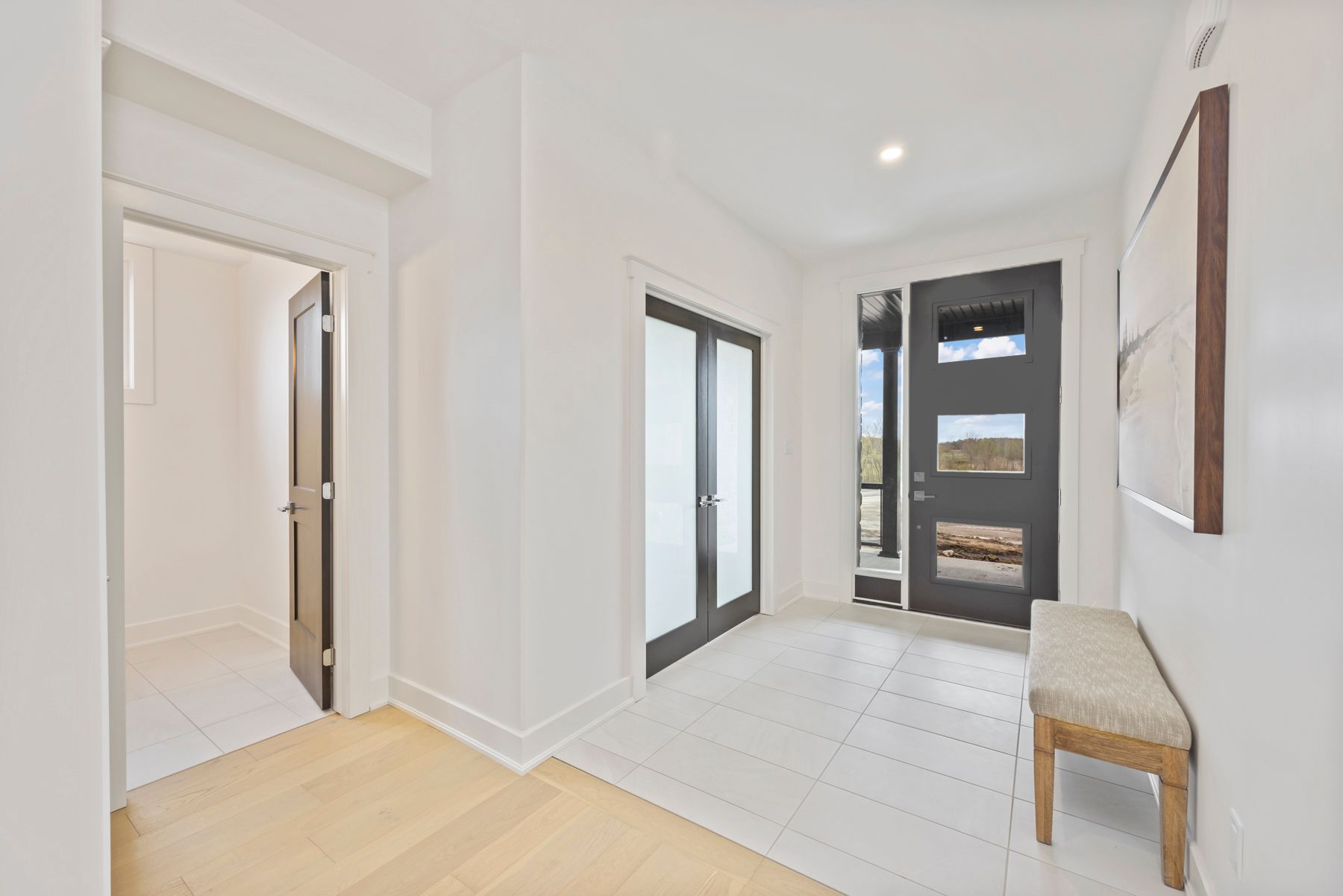 A hallway with a bench and a door in a house.