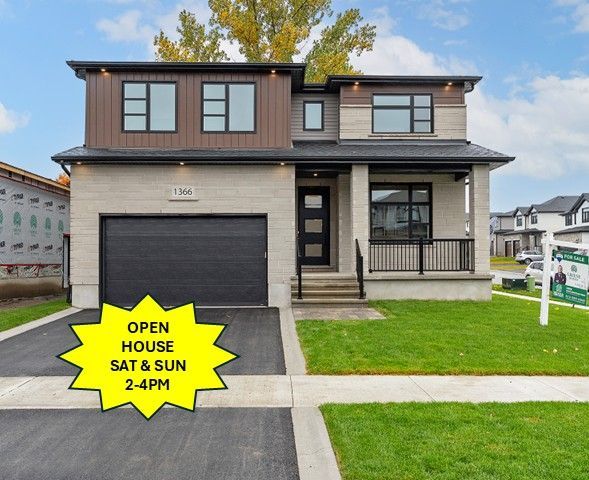 A large house is sitting on top of a lush green lawn in a residential area.