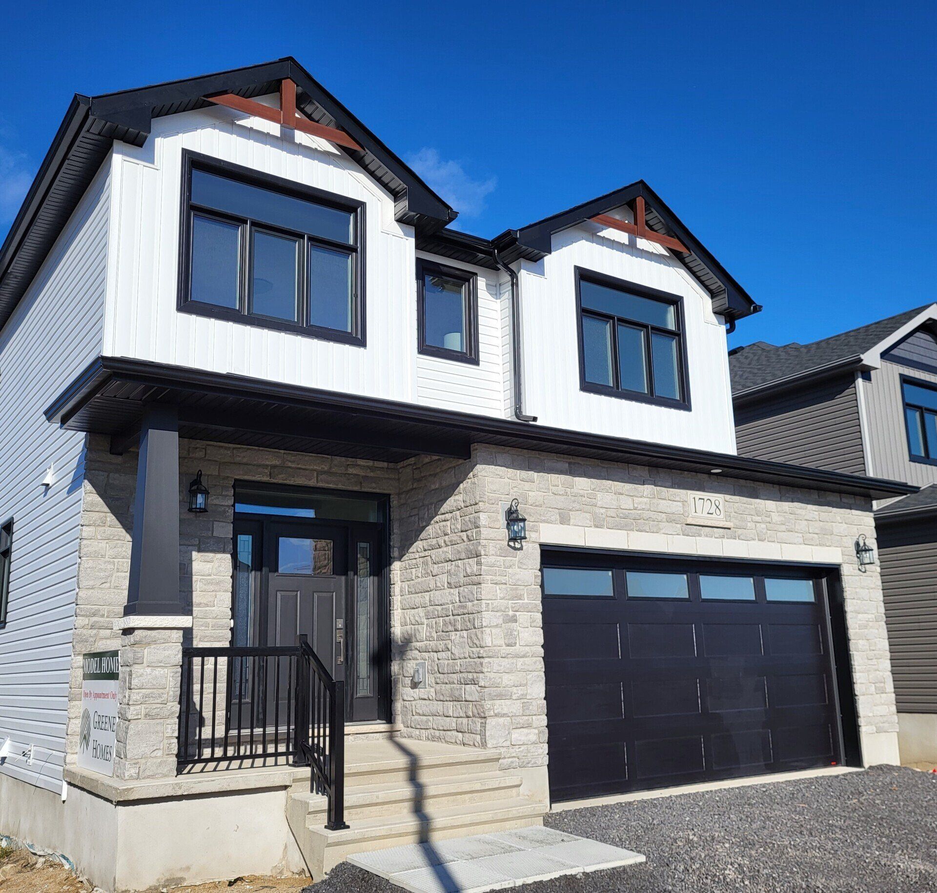 A white and black house with a black garage door