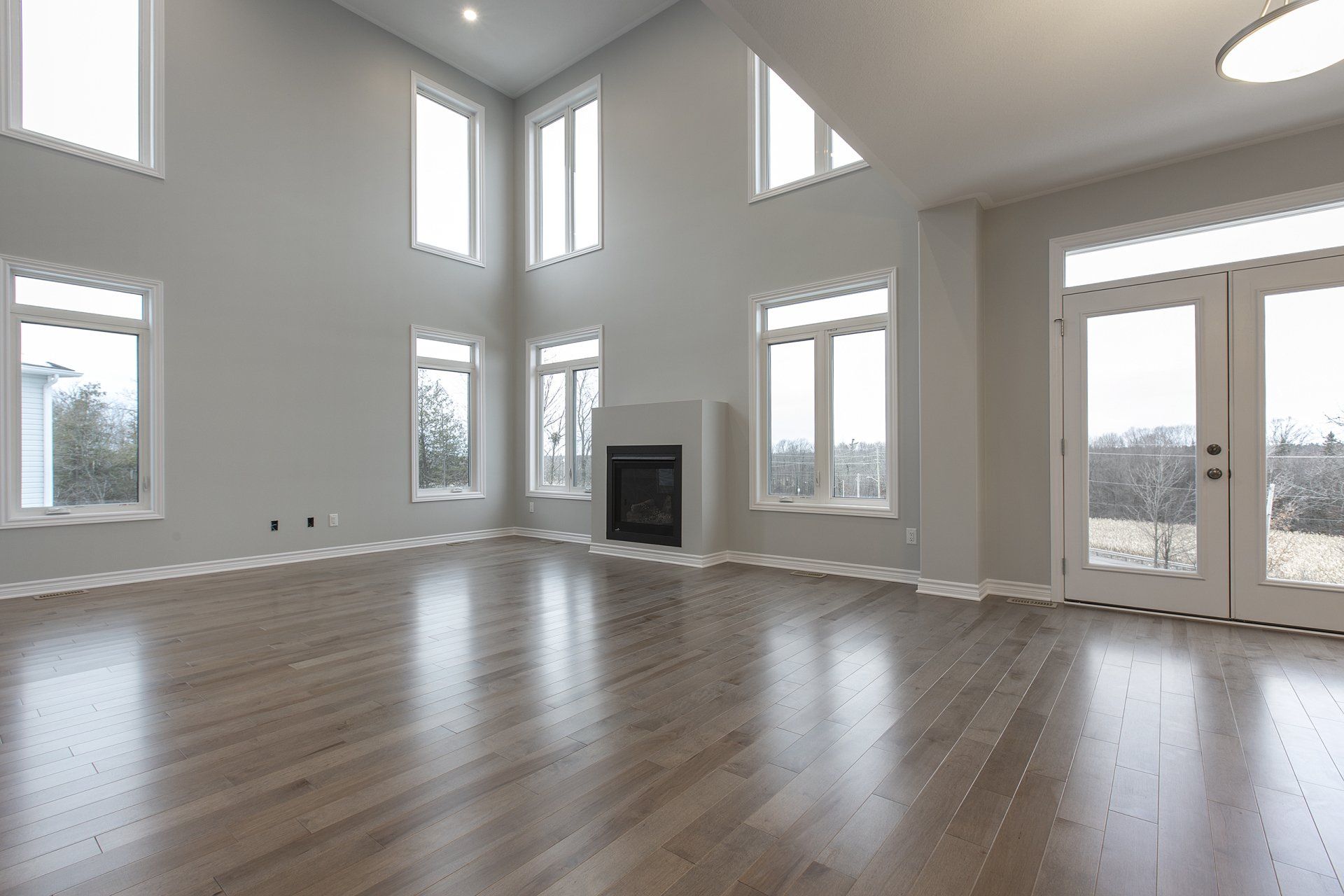 An empty living room with hardwood floors and a fireplace.