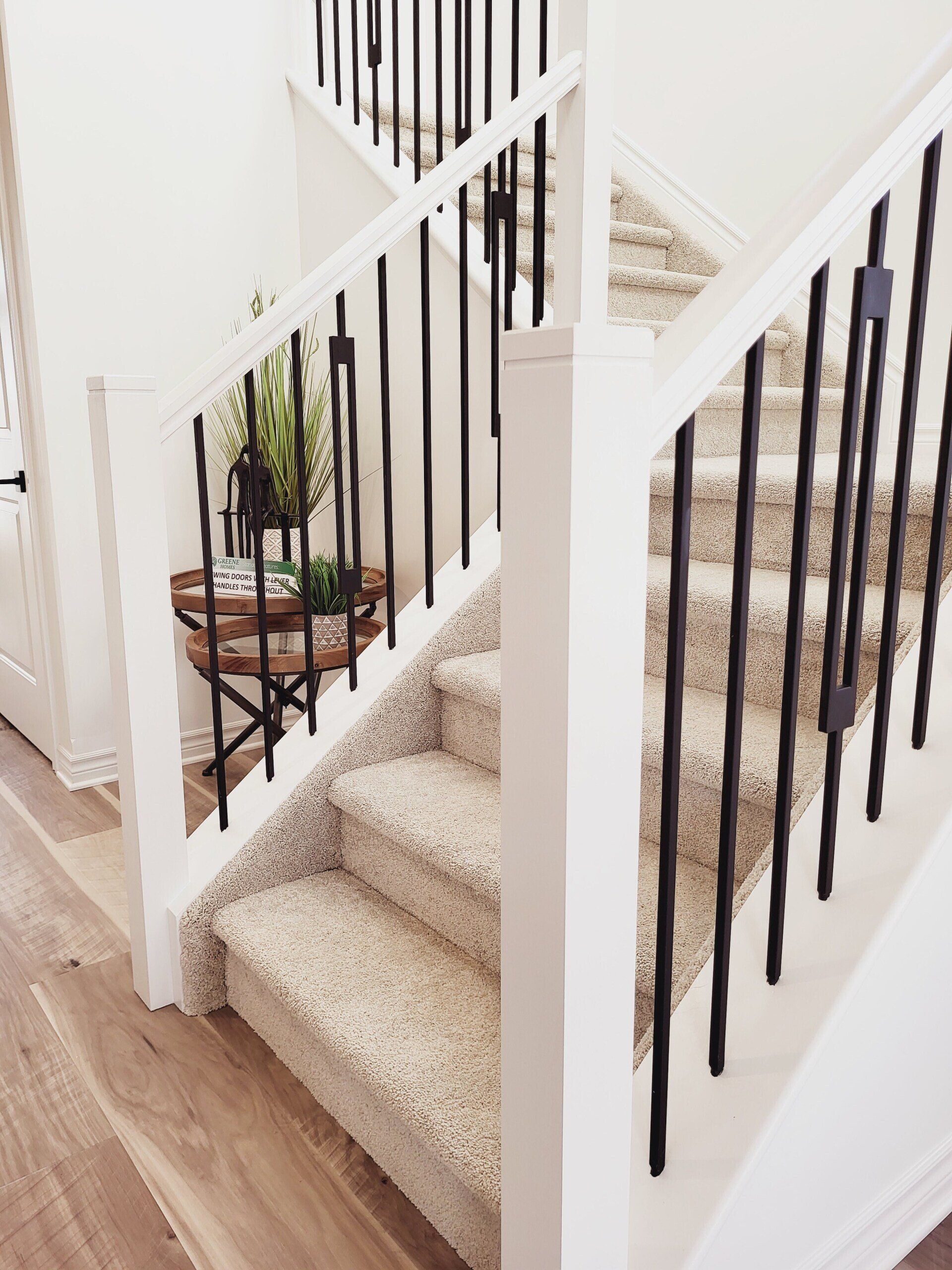 A staircase with a black railing and carpeted steps in a house.