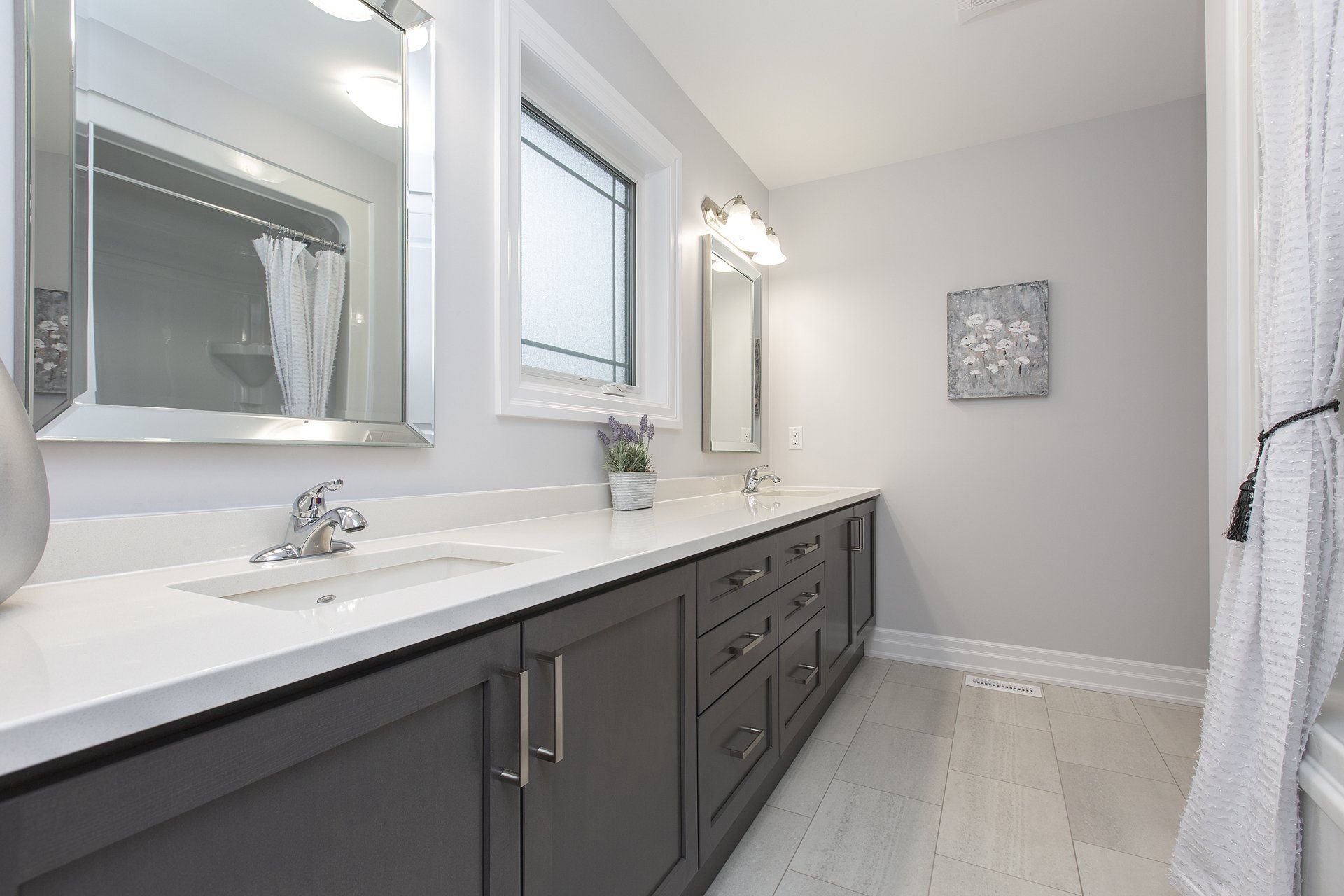 A bathroom with two sinks , a mirror and a tub.