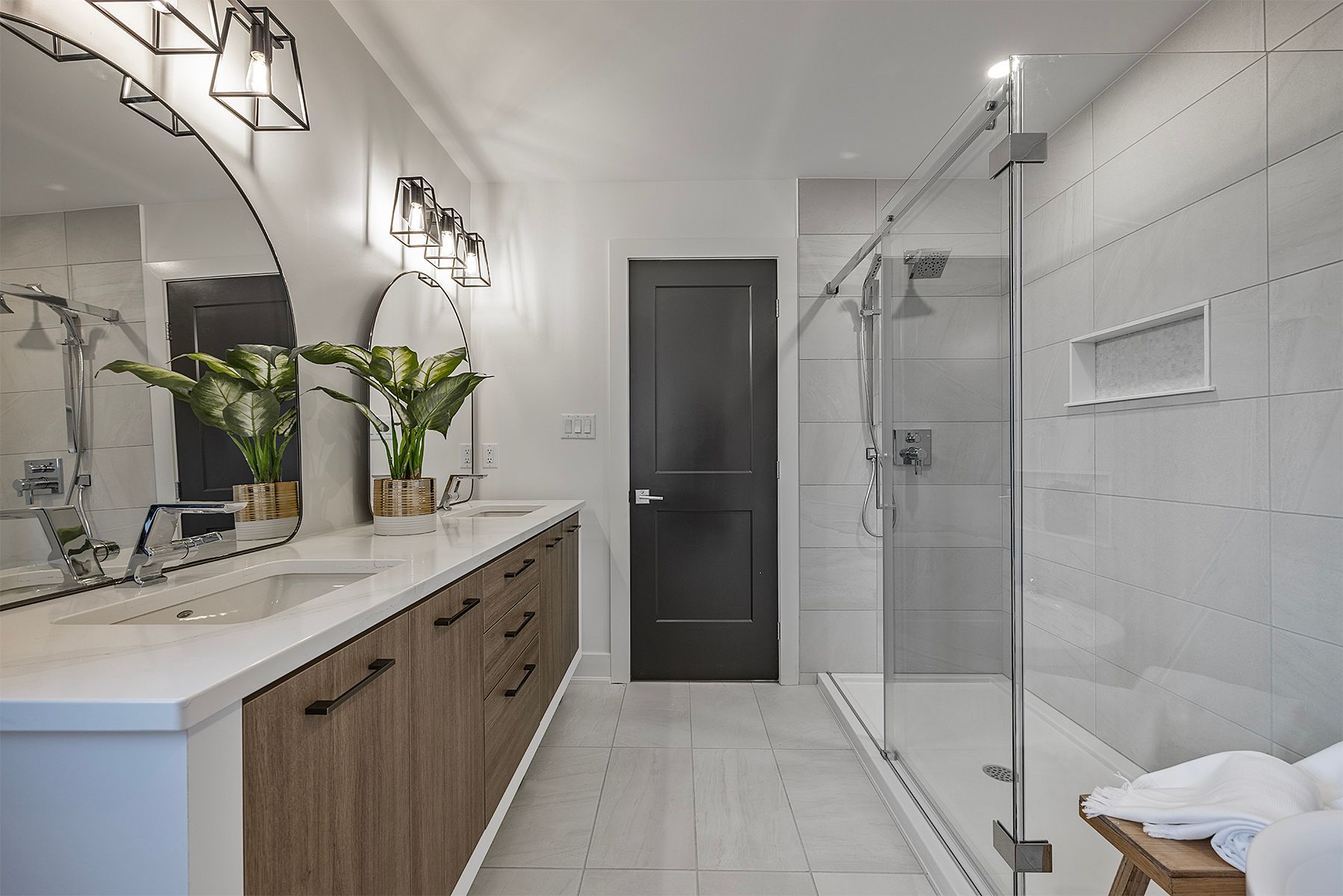 A bathroom with two sinks and a walk in shower.
