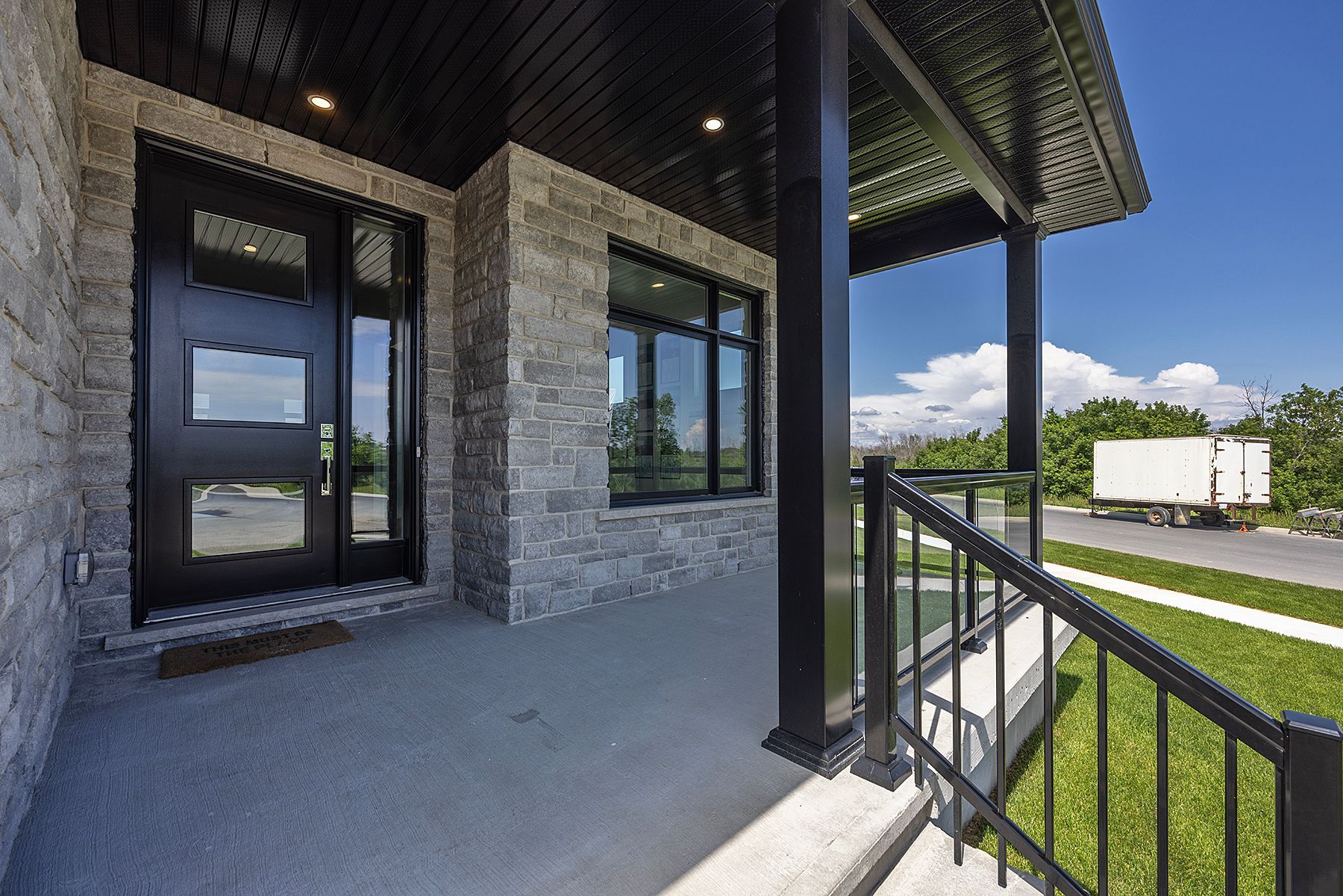 The front porch of a house with a truck in the background.