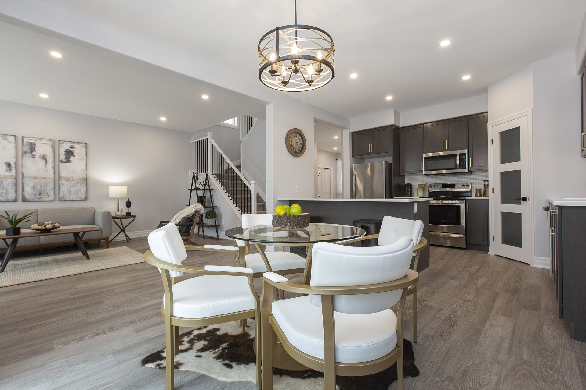 A living room with a dining table and chairs and a kitchen.