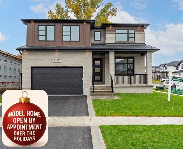 A large house is sitting on top of a lush green lawn in a residential area.