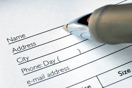 Pen filling out a form with fields for name, address, city, phone, and e-mail address