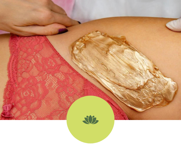 A woman is getting a wax treatment on her thigh