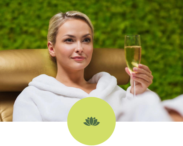 A woman in a bathrobe is holding a glass of champagne.