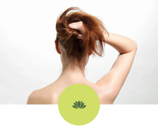 A woman is holding her hair in a ponytail.