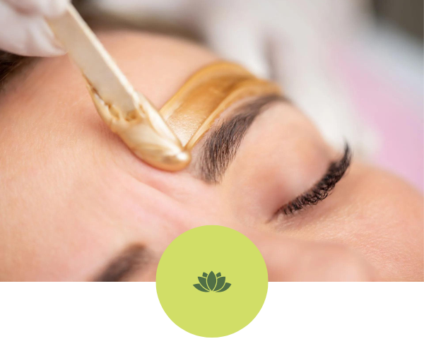 A woman is getting her eyebrows waxed in a beauty salon