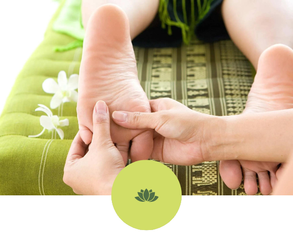 A person is getting a foot massage on a green mat