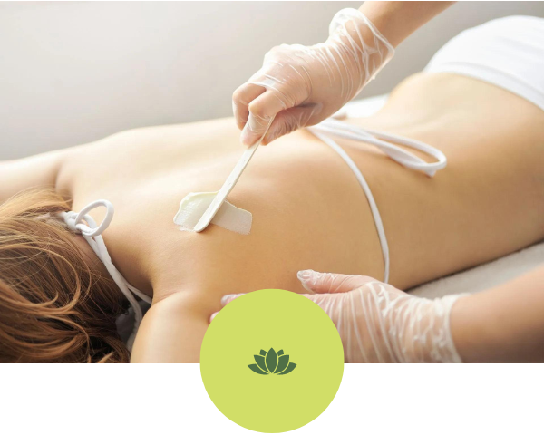 A woman is getting a wax treatment on her back