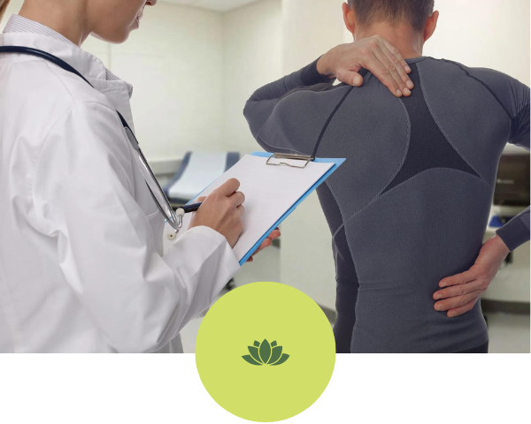 A doctor is examining a man 's back and writing on a clipboard