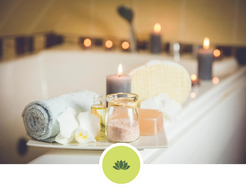 A bathtub filled with towels , candles , and soap.