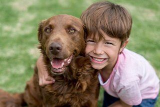 A boy with his dog that has a veterinarian serving Fort Pierce, FL
