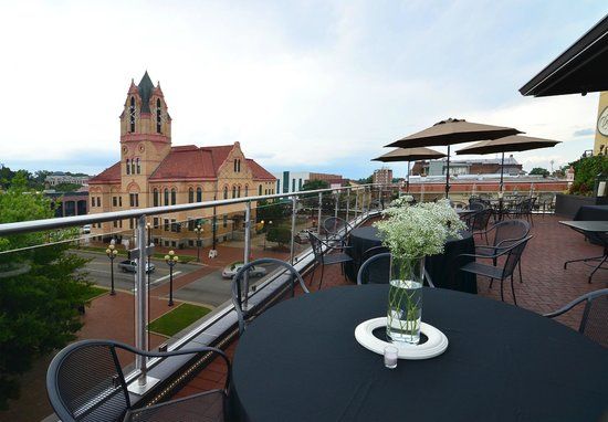 A table with a vase of flowers on it in front of a building