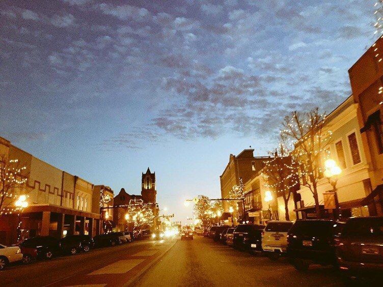 A city street at night with a clock tower in the background