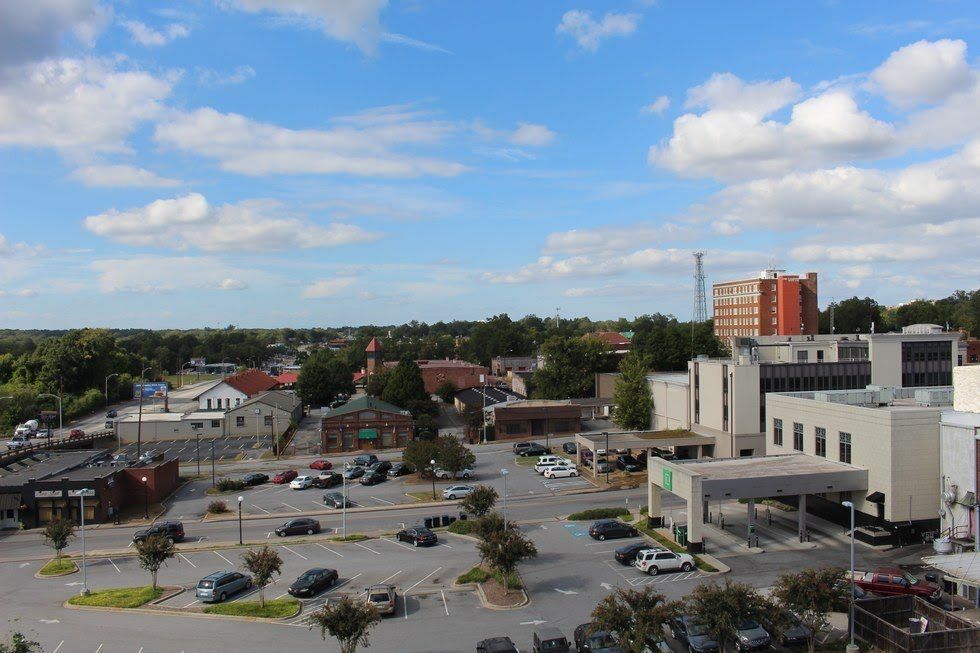 An aerial view of a parking lot with a hospital in the background.