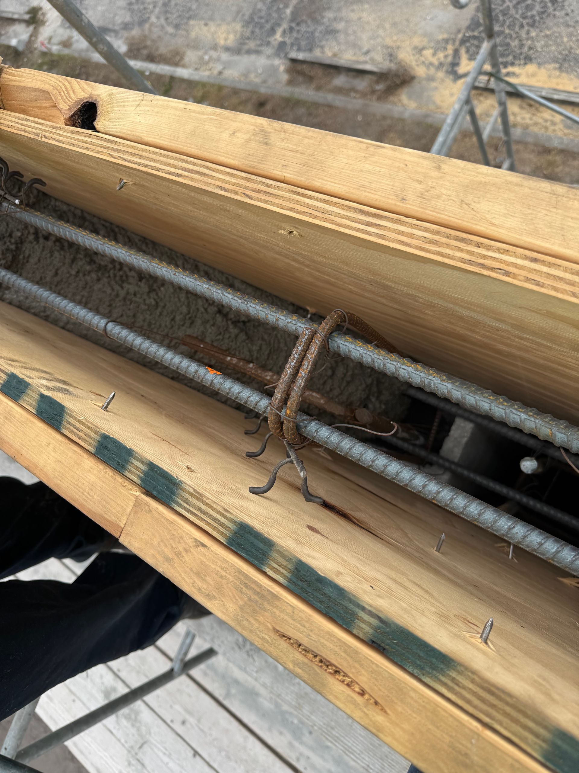 Reinforcing steel bars tied together inside a wooden form, ready for concrete.