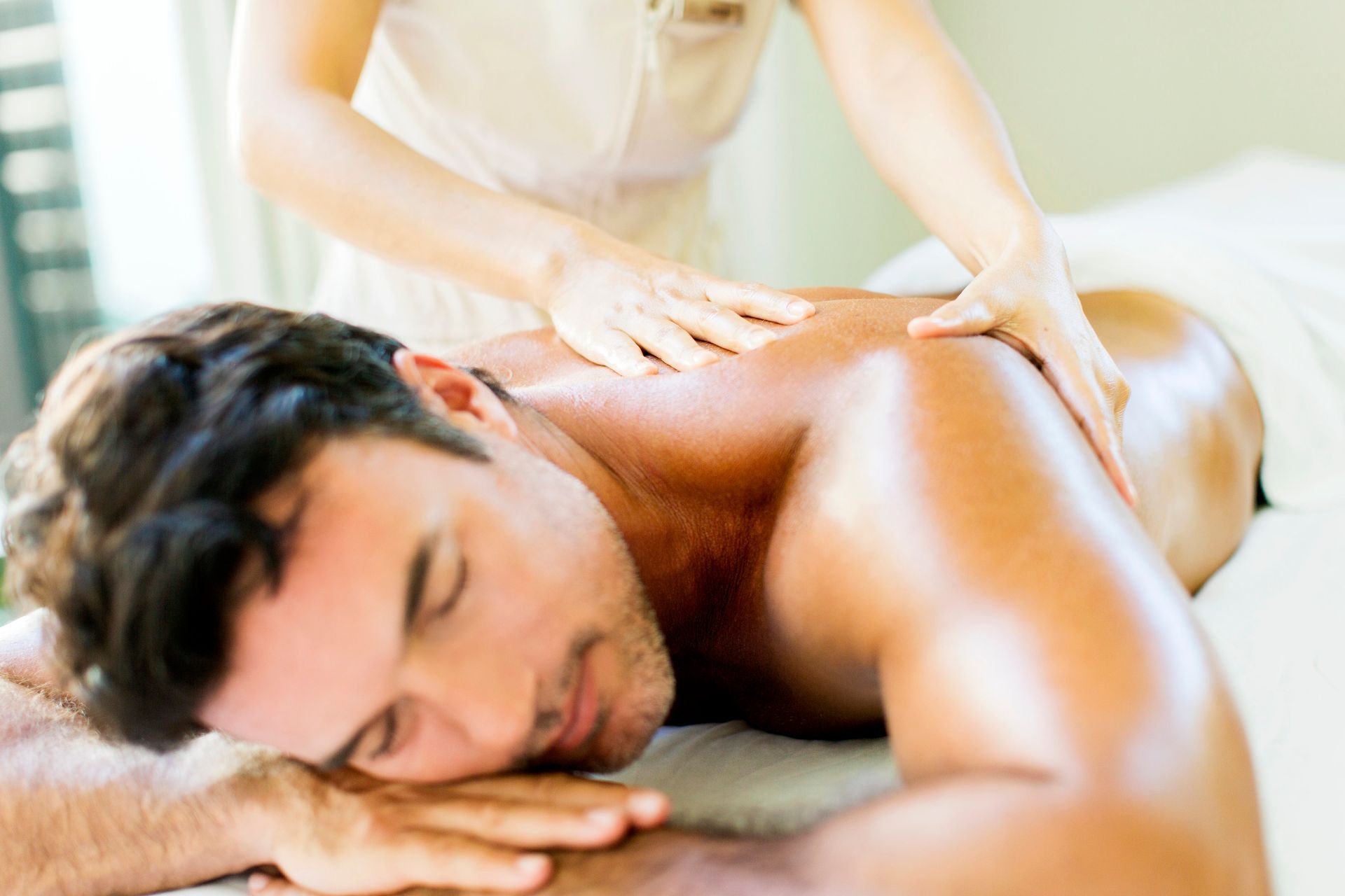 A man is laying on a table getting a massage