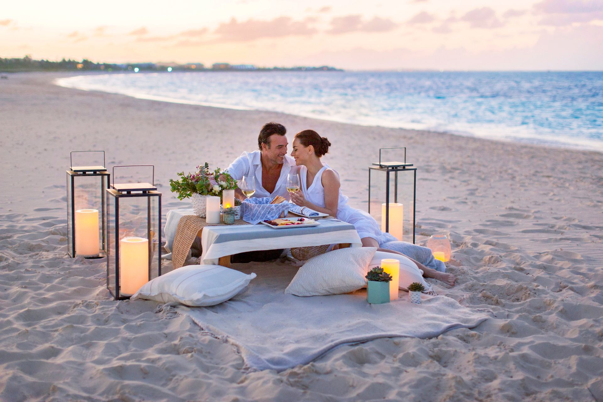 A man and woman are having a picnic on the beach
