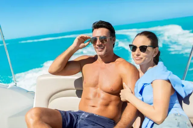 A man and a woman are sitting on a boat in the ocean