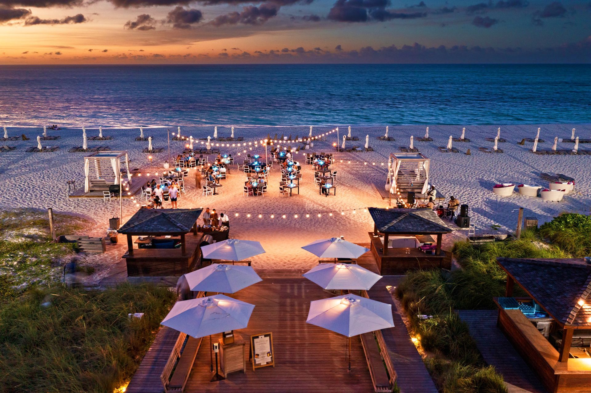 An aerial view of a beach with umbrellas and tables