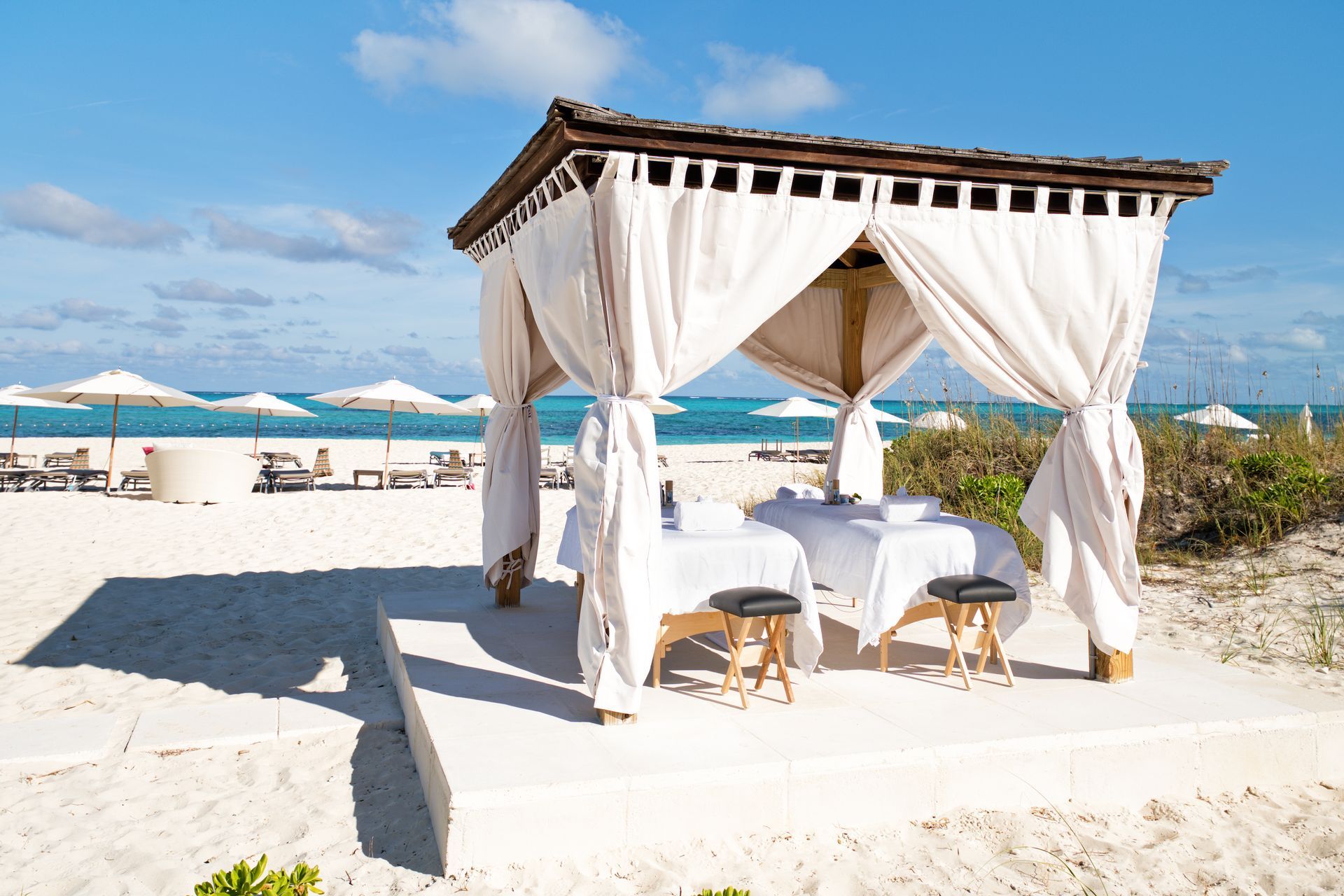 A gazebo on the beach with a table underneath it