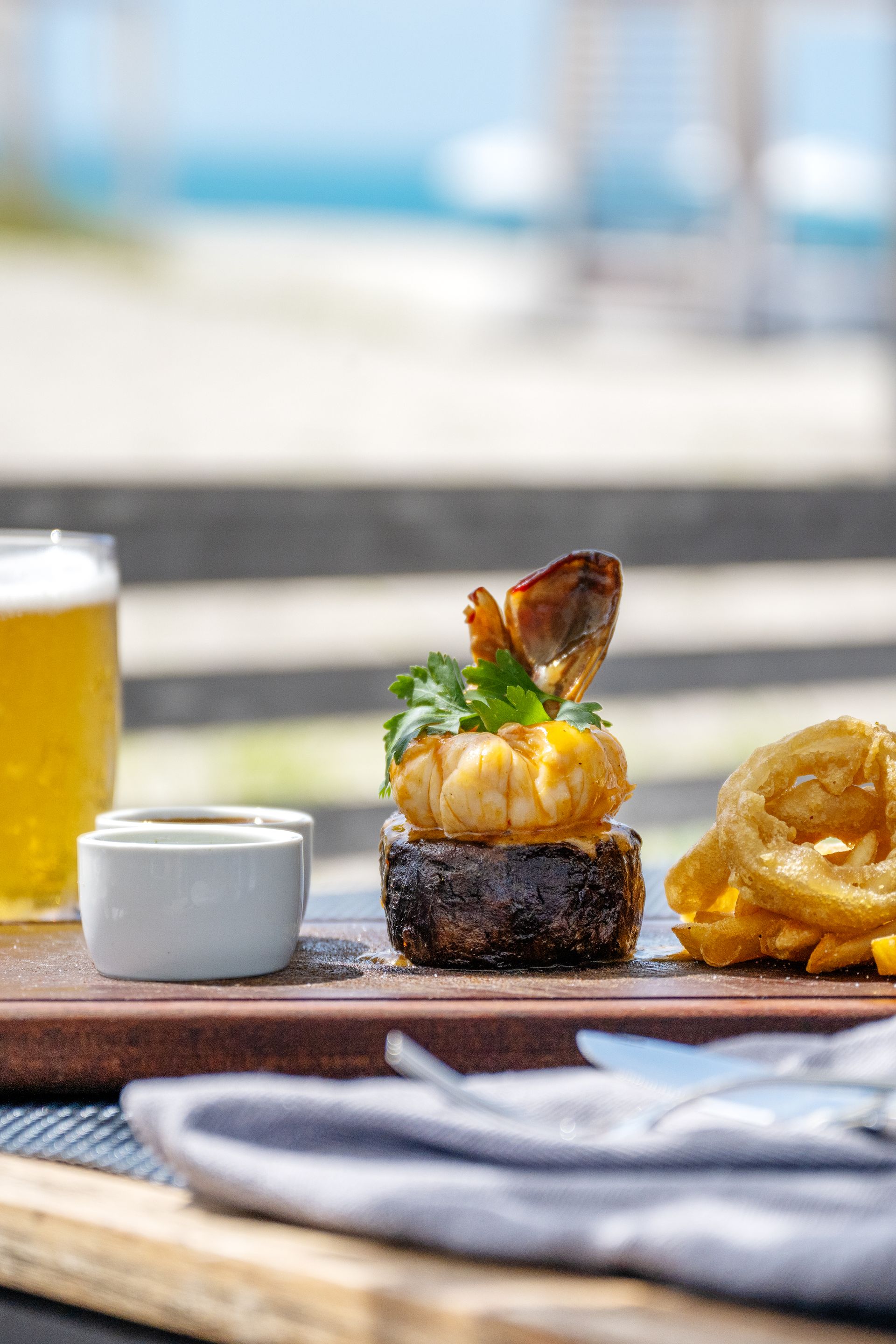 A tray of food with a glass of beer in the background