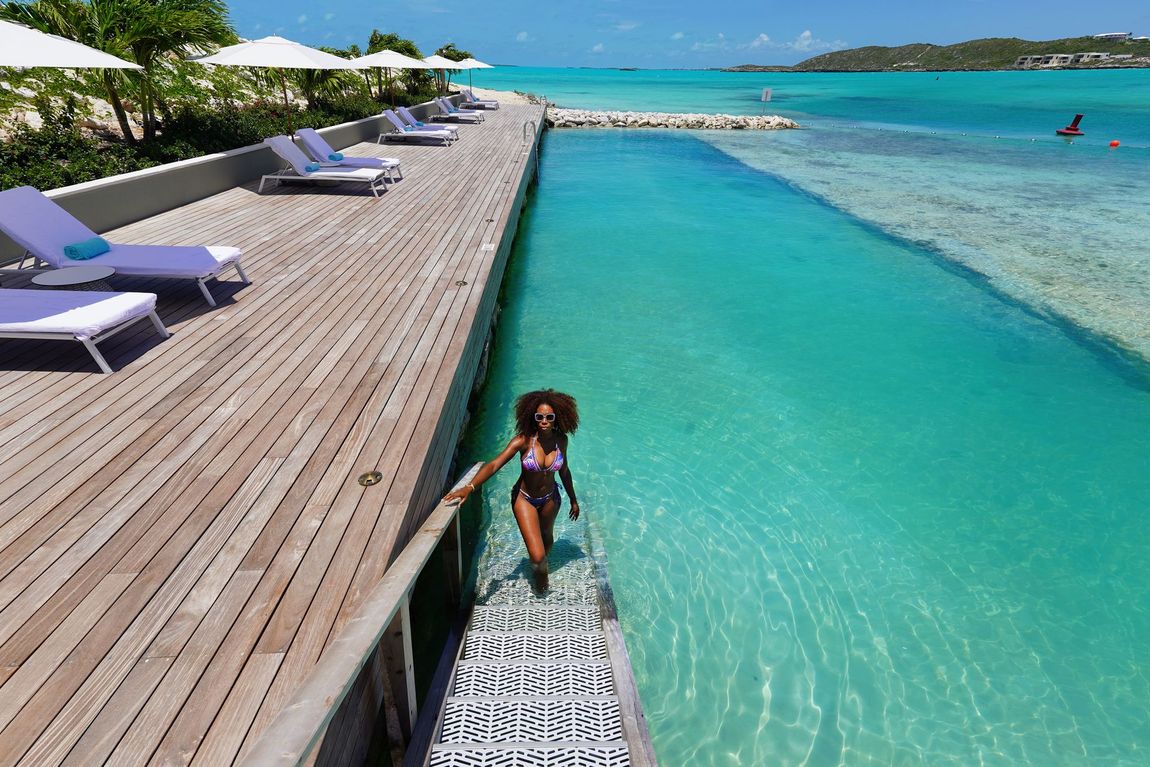 A woman in a bikini walks out of a swimming pool