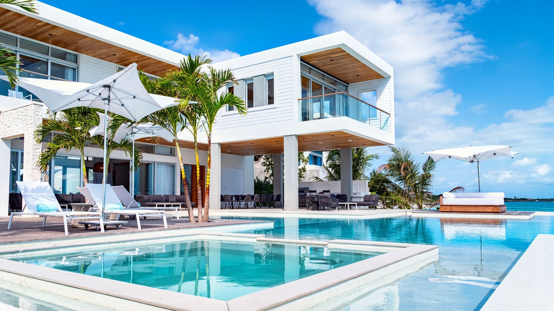 A large white house with a swimming pool in front of it