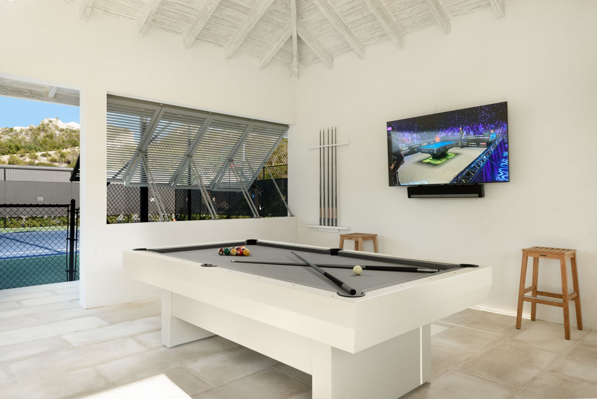 A pool table with a flat screen tv above it