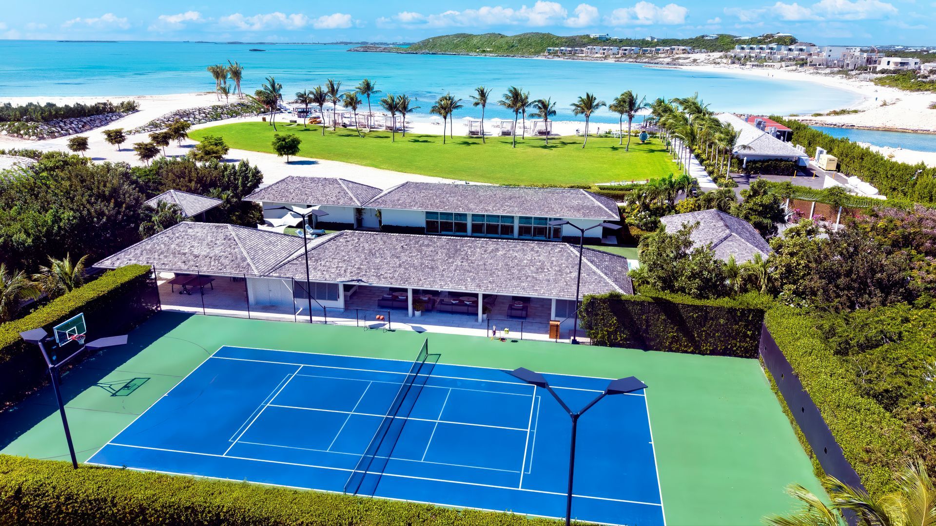 An aerial view of a tennis court with the ocean in the background