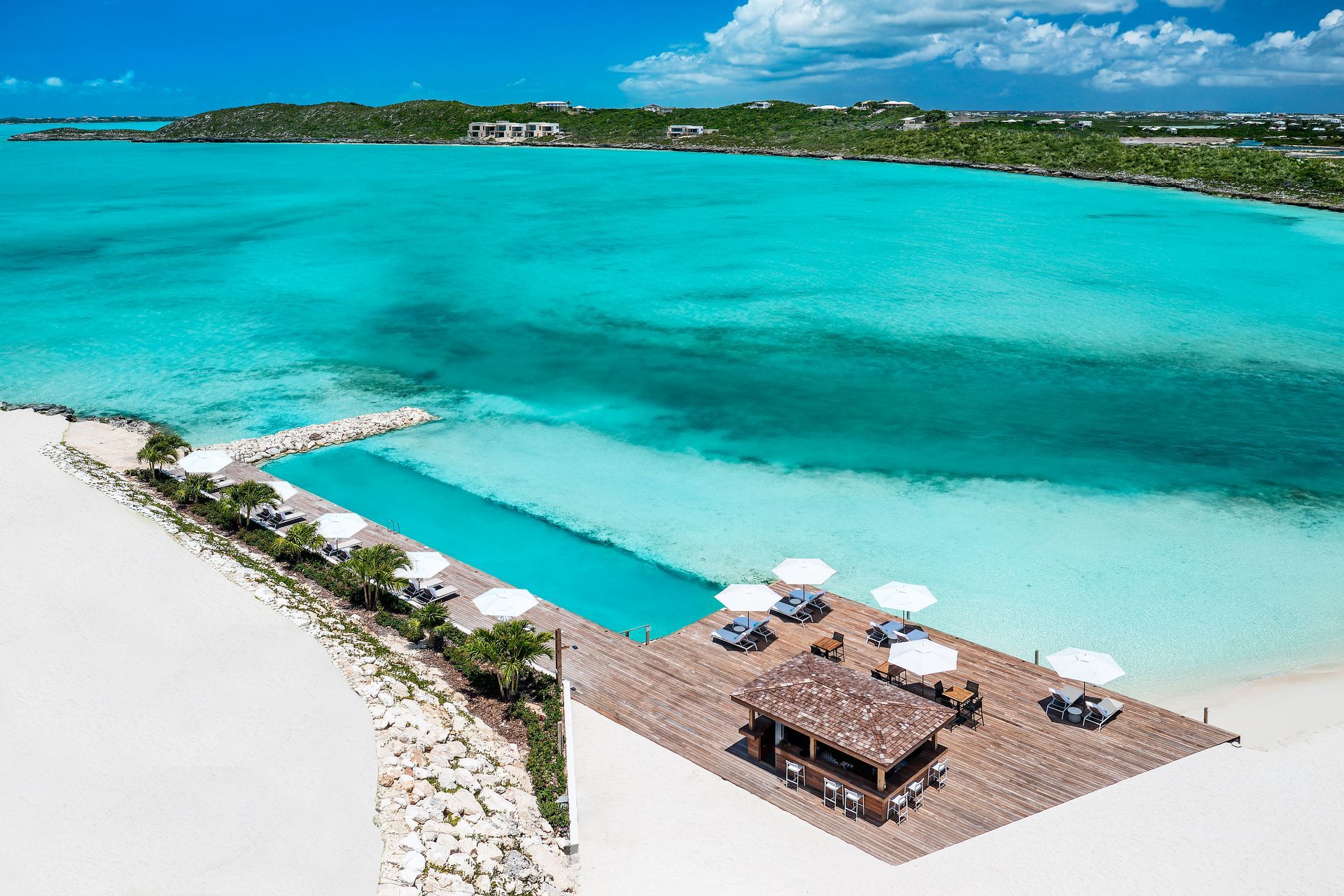 An aerial view of a beach with chairs and umbrellas