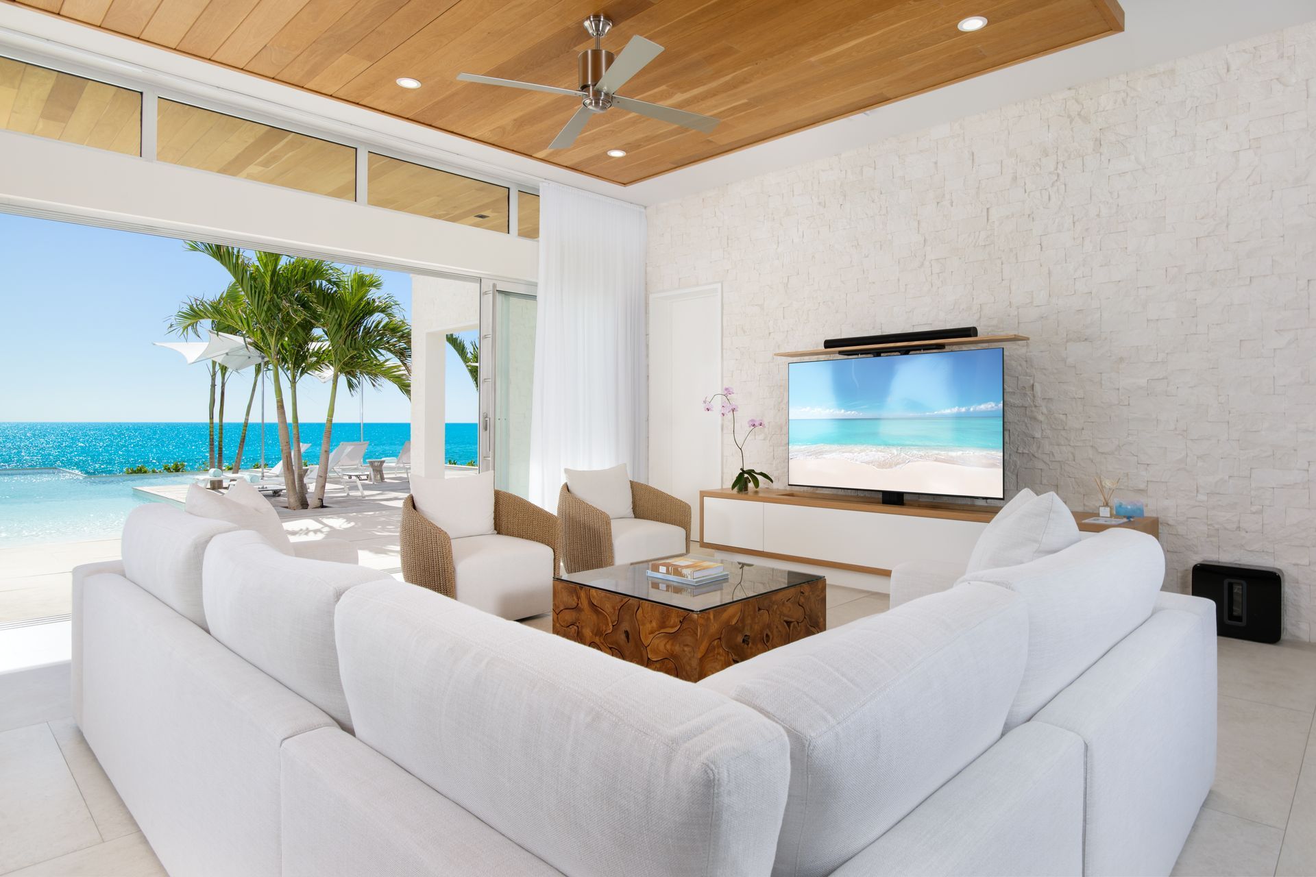 A living room with white furniture and a ceiling fan