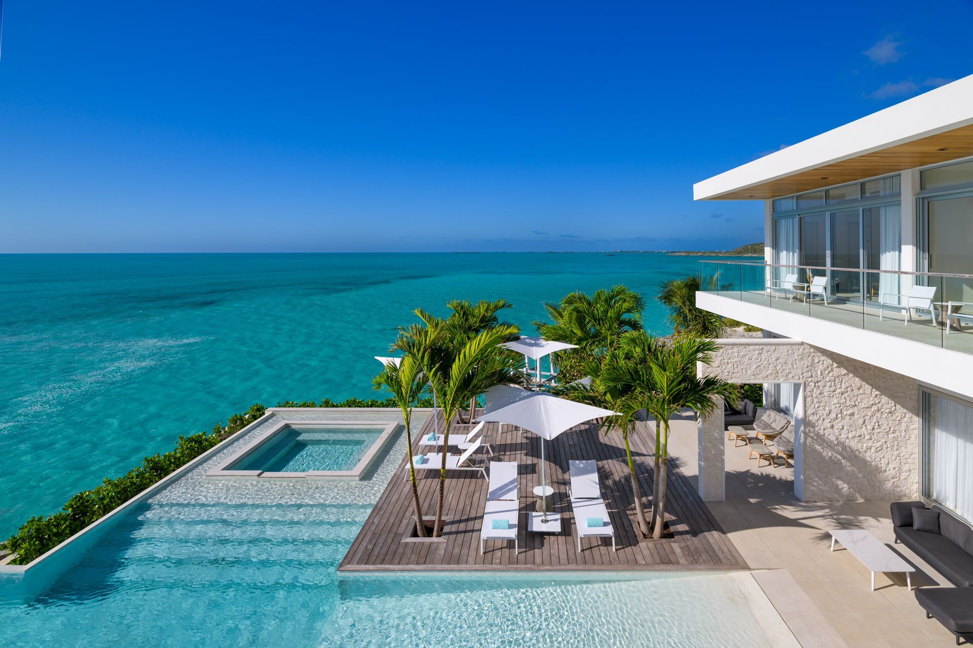 A swimming pool with two lounge chairs and an umbrella