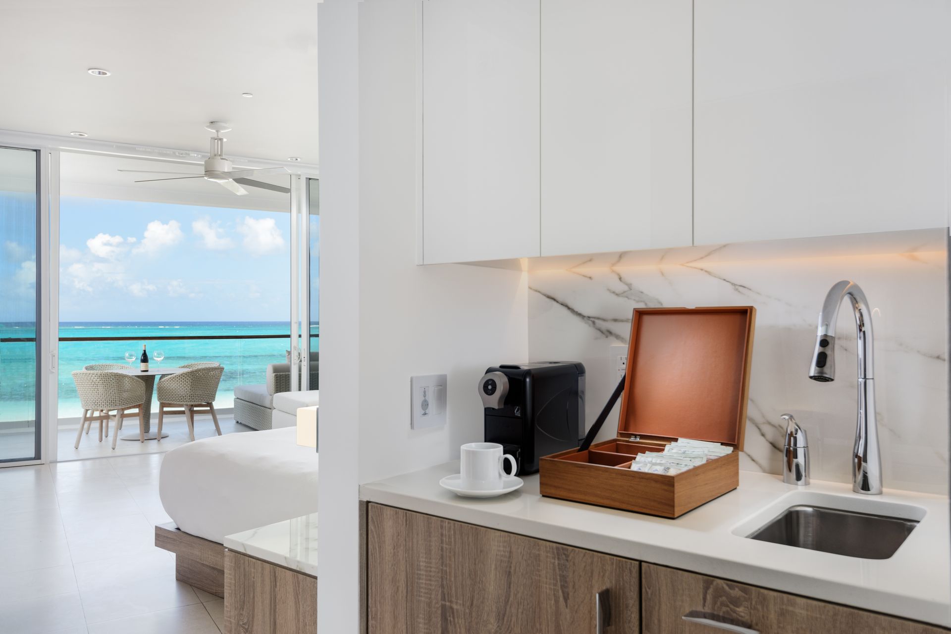 A kitchen in a hotel room with a view of the ocean