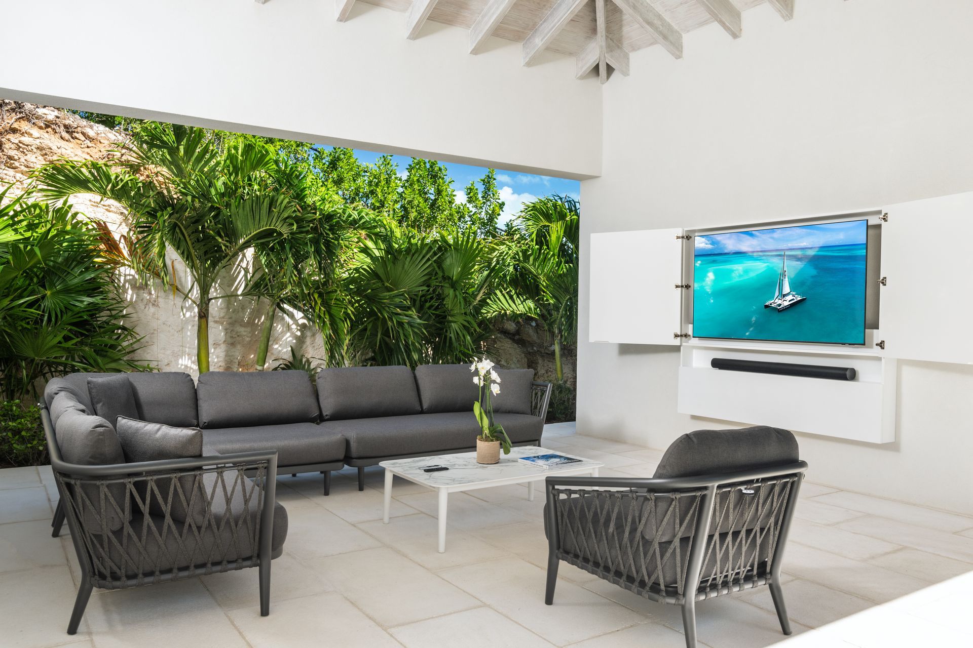A living room with a couch and chairs and a flat screen tv