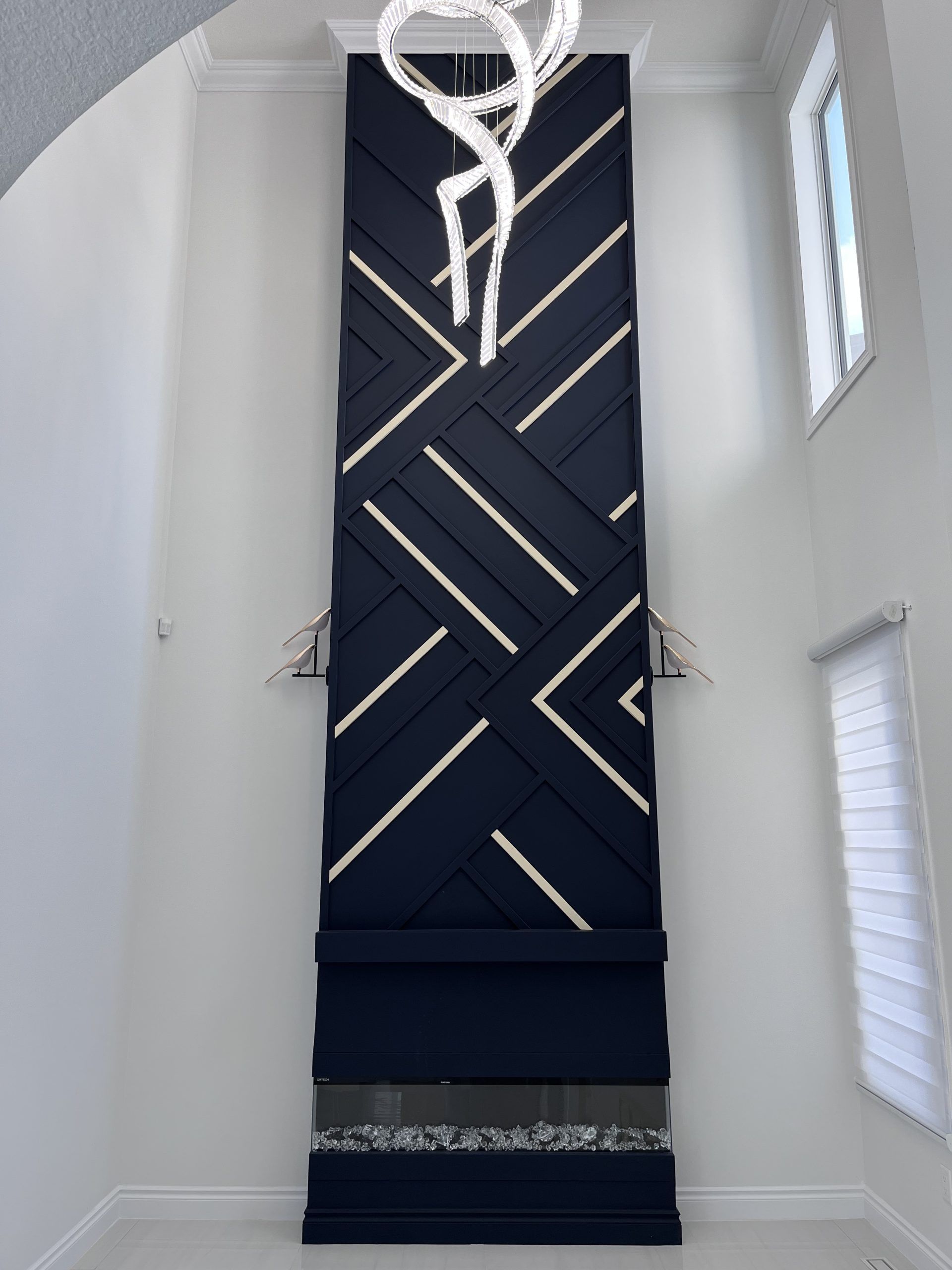 Tall navy geometric fabric wall hanging in a bright white stairwell or hallway