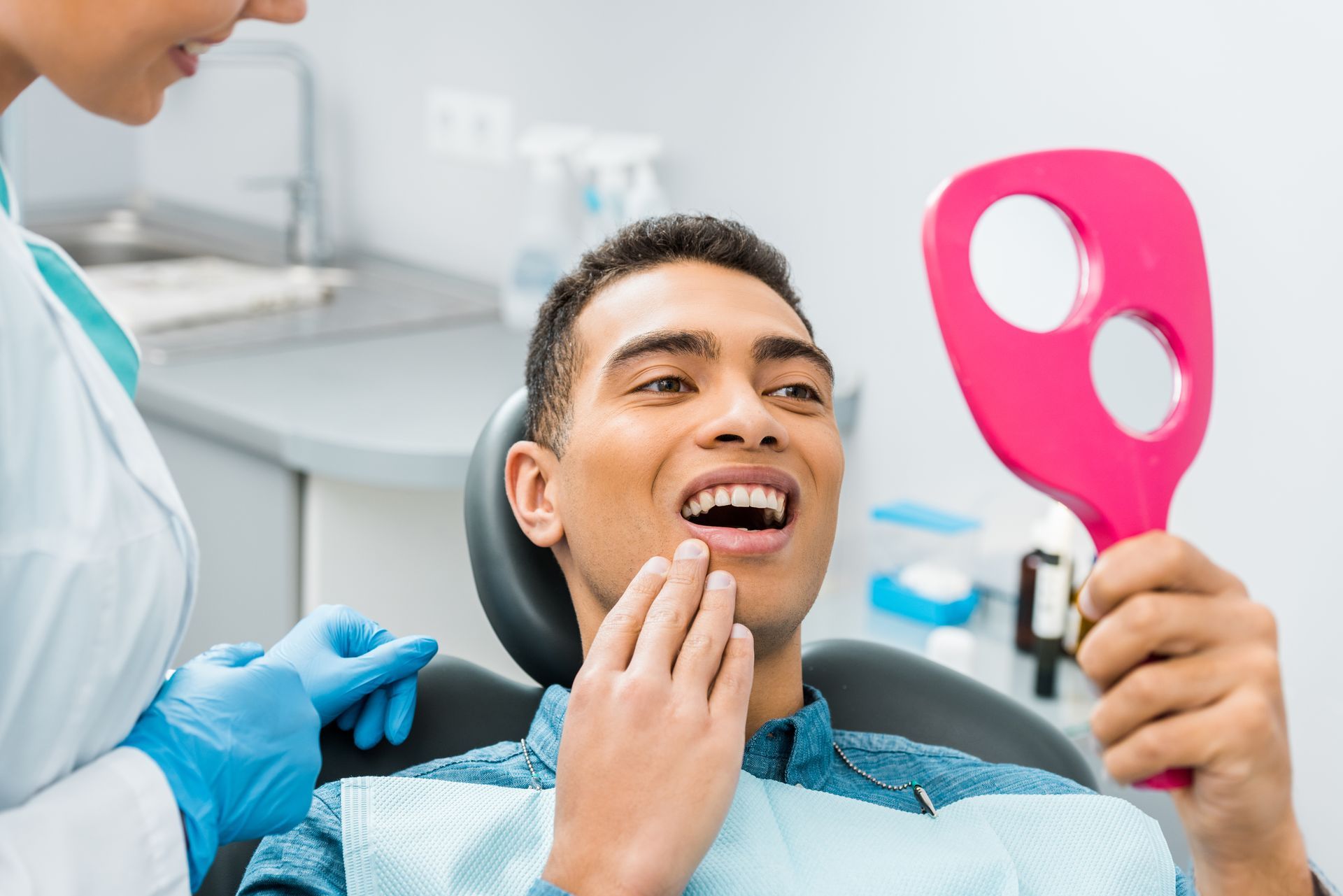 A woman is getting her teeth whitened by a dentist.