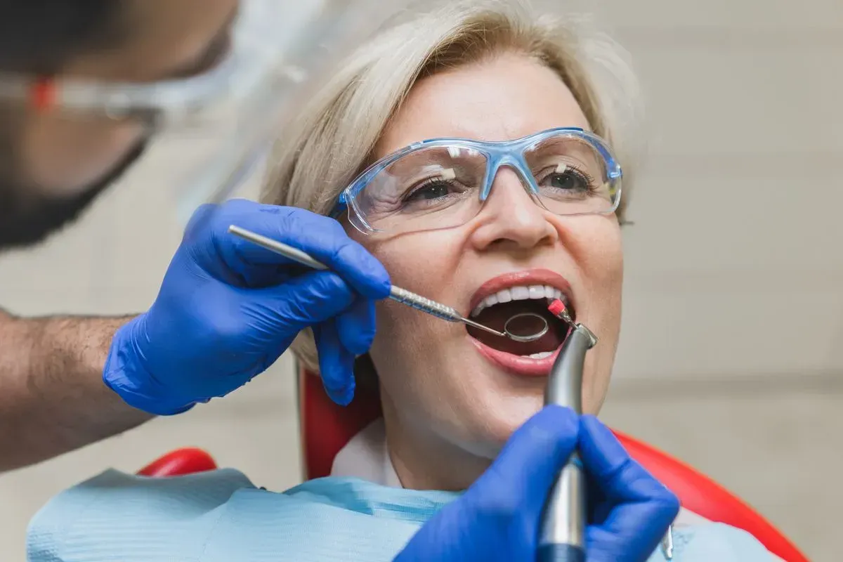 A woman is getting her teeth examined by a dentist.